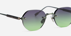 Frontalansicht einer randlosen Sonnenbrille mit violett-grünem Farbverlauf der Gläser und schlanken Metallbügeln.