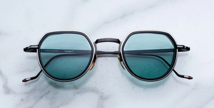 jacques marie mage dixon paon pantoförmige sonnenbrille aus titan und acetat in schwarz und silber mit türkisenen Gläsern