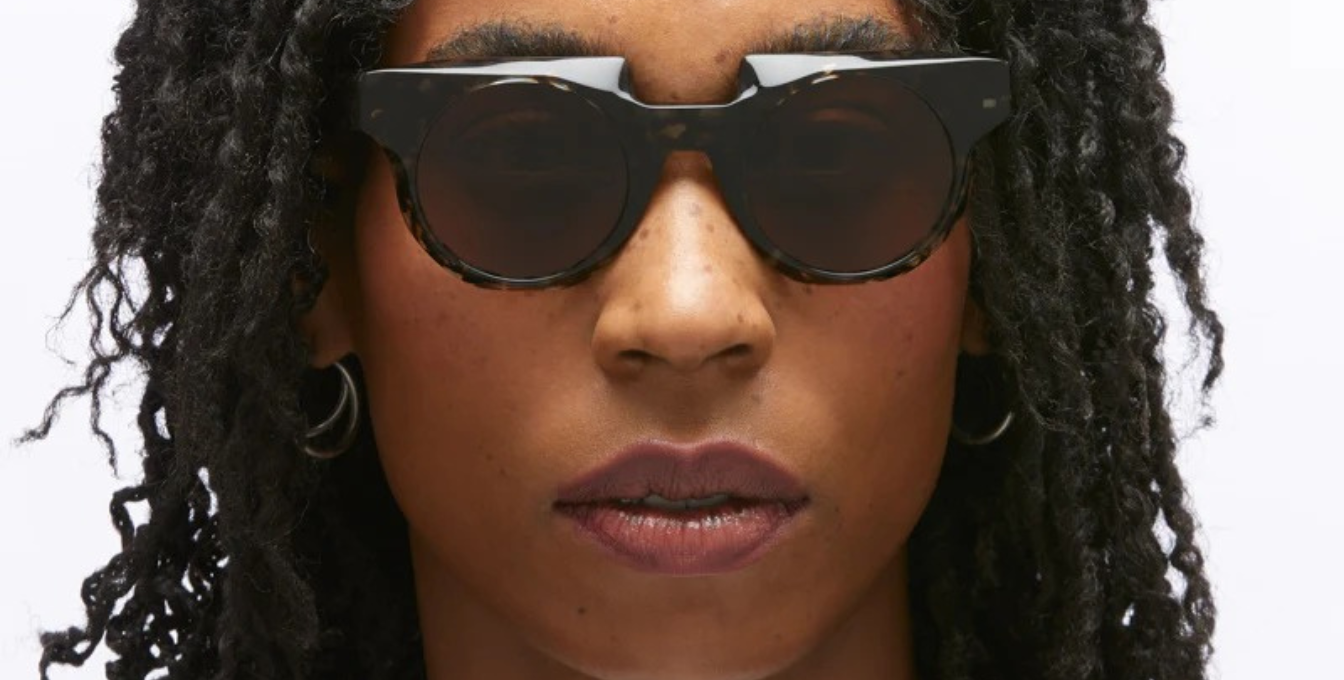 Model trägt Kuboraum U1 GYH mit runde Sonnenbrille mit gelben Gläsern 