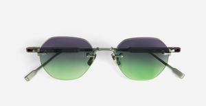 Nahaufnahme der randlosen Sonnenbrille mit violett-grün getönten Gläsern, sichtbaren Metallbügeln und filigranem Nasensteg