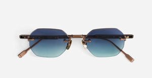 Randlose Sonnenbrille mit polygonalen blau-türkisen Gläsern und bronzefarbenen Metallbügeln in Frontalansicht