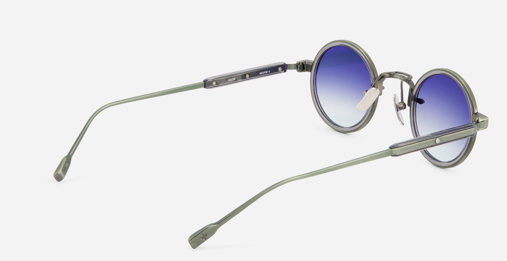 sato naos mg/gc-1 runde sonnenbrille aus titan und acetat in grün und grau mit blauen verlaufsgläsern