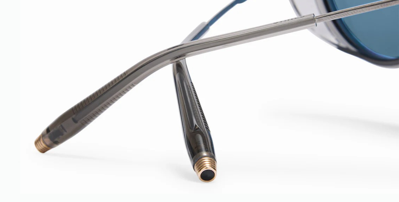 akoni astria crystal grey ovale sonnenbrille aus titan und acetat in silber und grau mit blauen verspiegelten gläsern