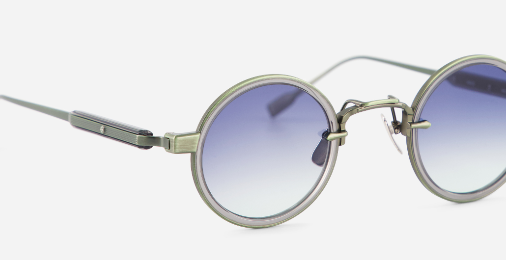 sato naos mg/gc-1 runde sonnenbrille aus titan und acetat in grün und grau mit blauen verlaufsgläsern
