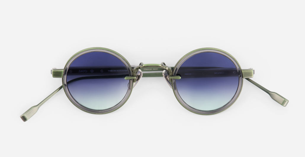 sato naos mg/gc-1 runde sonnenbrille aus titan und acetat in grün und grau mit blauen verlaufsgläsern