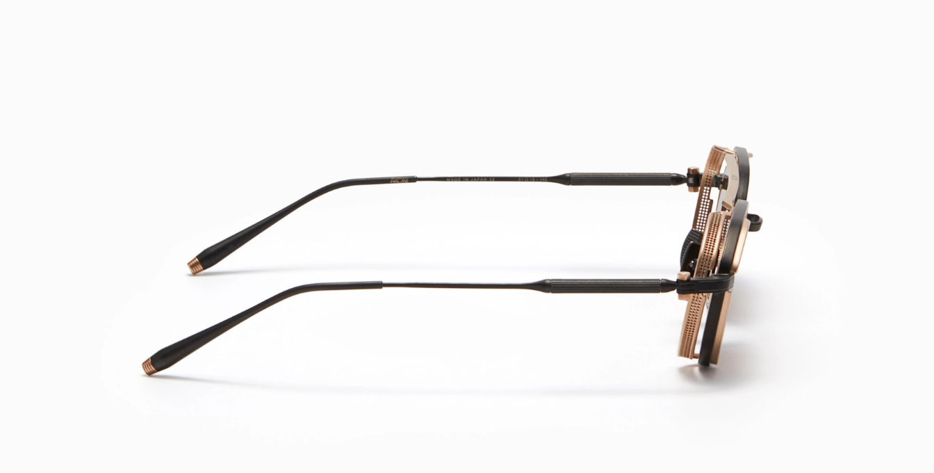 akoni eris-two brushed black ovale sonnenbrille in matt schwarz und golg mit braunen gläsern