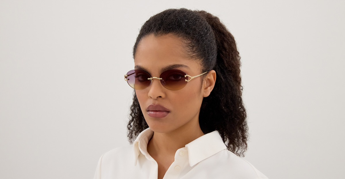 cartier 0551S 006 ovale sonnenbrille in gold und violetten gläsern